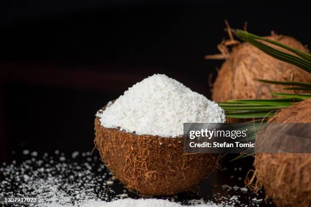 grated coconut powder falling out of a coconut shell with copy space - flour stock pictures, royalty-free photos & images