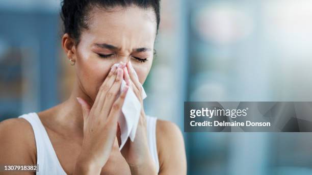 sto scendendo con l'influenza - closeup of a hispanic woman sneezing foto e immagini stock