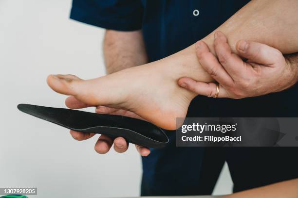 pied de jeune femme sur des semelles orthopédiques pour la correction médicale de pied - plante des pieds photos et images de collection