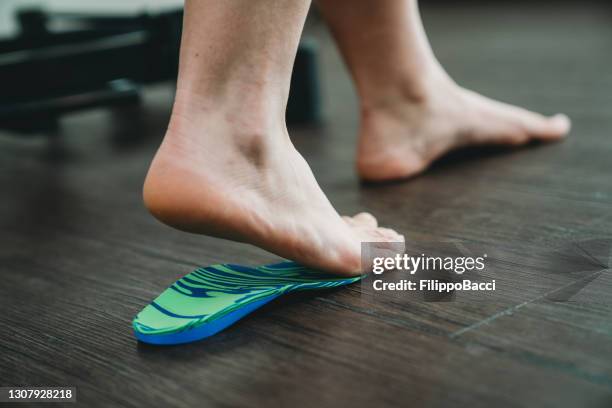 de voet van de jonge vrouw op orthopedische inlegzolen voor medische voetcorrectie - female feet soles stockfoto's en -beelden