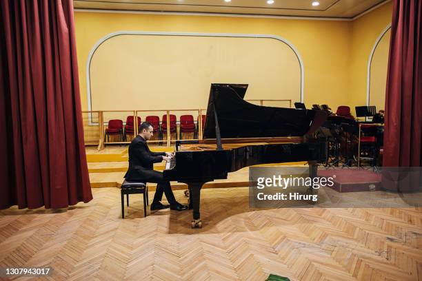 männliches klavierspiel im konzertsaal - pianist stock-fotos und bilder