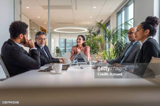 asian businesswoman conducting business meeting in boardroom - board room stock pictures, royalty-free photos & images