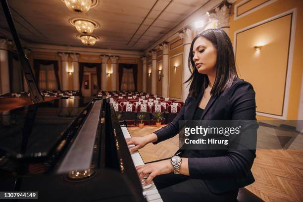 female playing piano at concert hall - pianist imagens e fotografias de stock