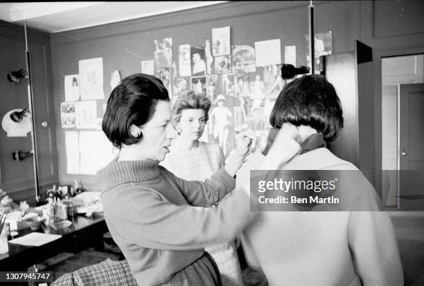 Diana Vreeland , Editor-in-Chief of Vogue magazine adjusting a model's collar, May 1, 1963.