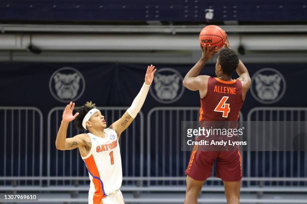 Nahiem Alleyne of the Virginia Tech Hokies shoots a 3-point basket against Tre Mann of the Florida Gators to tie the game in the second half in the...