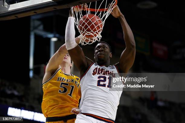 Kofi Cockburn of the Illinois Fighting Illini dunks the ball past James Butler of the Drexel Dragons in the second half of the first round game of...