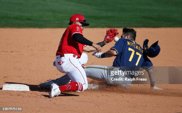Garrett Mitchell of the Milwaukee Brewers slides into second base on a steal as shortstop Franklin Barreto of the Los Angeles Angels fields the throw...