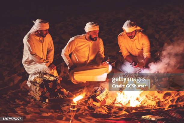 amis arabes à un camp de désert grillant le kebab frais - arabian desert adventure night photos et images de collection