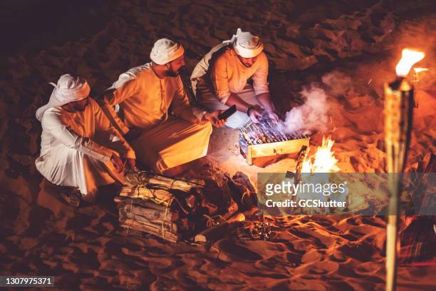 amis arabes à un camp de désert grillant le kebab frais - arabian desert adventure night photos et images de collection