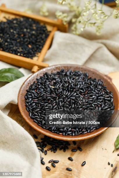 high angle view of black sesame seeds on wooden table - black rice stock pictures, royalty-free photos & images