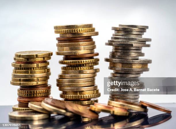 piles of savings coins on a white background. - pot of gold stock-fotos und bilder