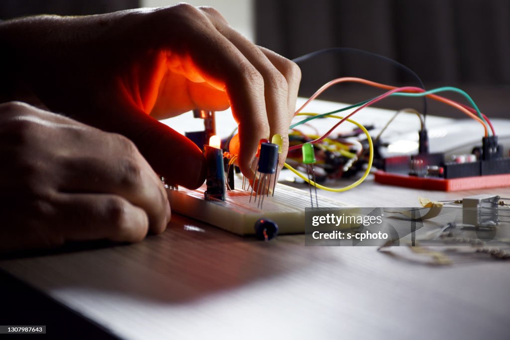 An engineer working on open-source hardware and software project, breadboard, electronic module