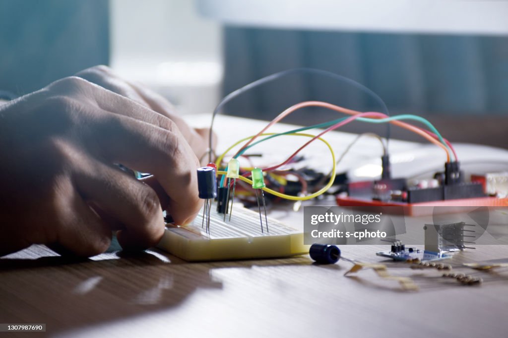 An engineer working on open-source hardware and software project, breadboard, electronic module