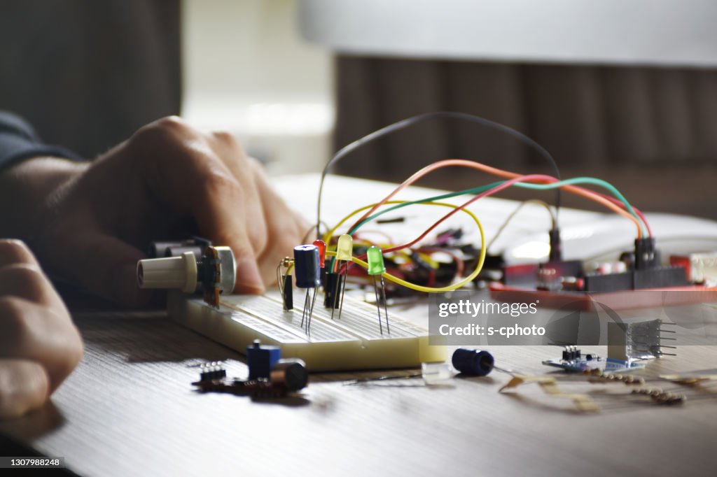 An engineer working on open-source hardware and software project, breadboard, electronic module