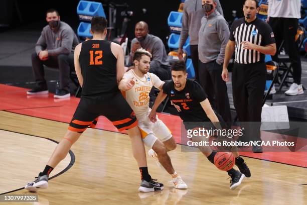 Jarod Lucas of the Oregon State Beavers dribbles around a screen by Roman Silva against the Tennessee Volunteers in the first round of the 2021 NCAA...