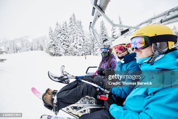 female adaptive athlete riding chair lift with friends at ski resort on winter morning - womens us ski team stock pictures, royalty-free photos & images