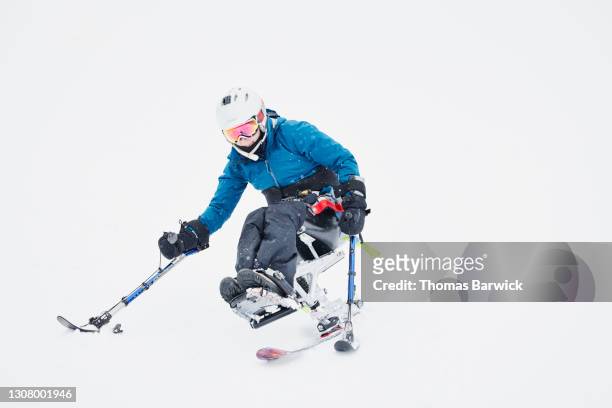 full length view of female adaptive athlete on monoski skiing on winter morning - alpine skiing stock pictures, royalty-free photos & images