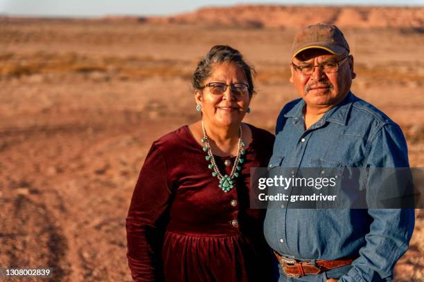 ein glücklicher, lächelnder indianer-ehemann und -frau in der nähe ihres hauses in monument valley, utah - indian old man stock-fotos und bilder