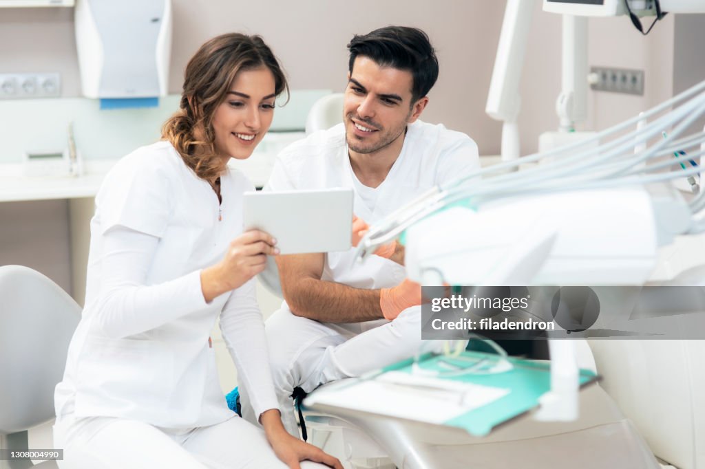 Zahnärzte mit Blick auf digitales Tablet