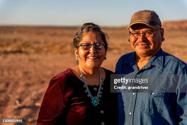 un feliz y sonriente esposo y esposa nativo americano cerca de su casa en monument valley, utah - cultura de indios norteamericanos fotografías e imágenes de stock