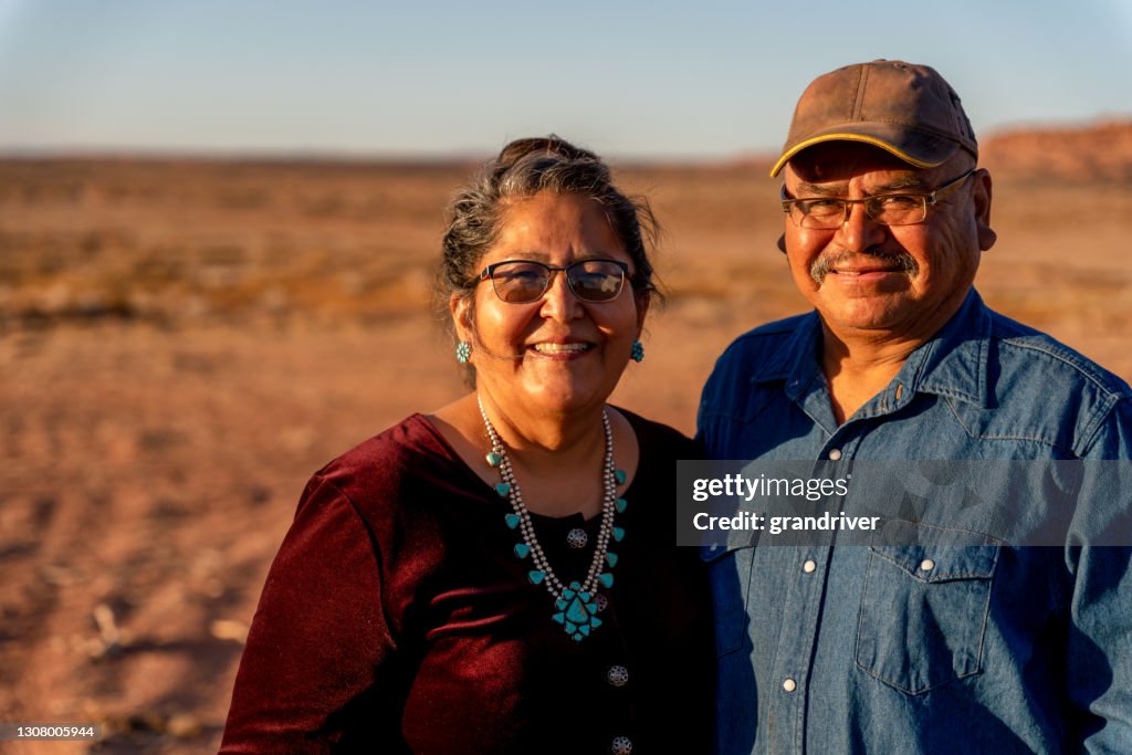 Een gelukkige, Glimlachende Inheemse Amerikaanse Echtgenoot en Vrouw dichtbij hun huis in De Vallei van het monument, Utah