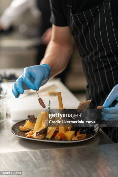 chef preparing an appetizer with cheese, grapes, walnut and fig - roquefort cheese stock pictures, royalty-free photos & images