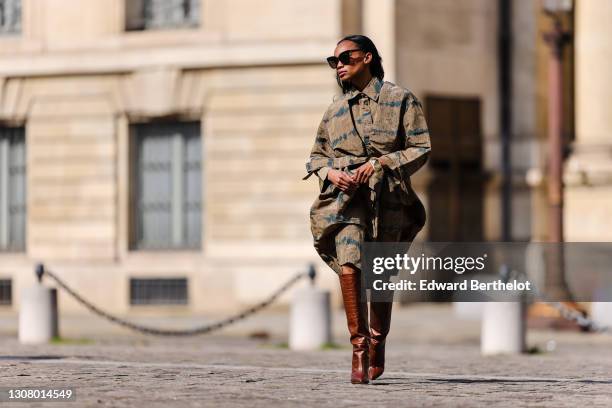 Emilie Joseph @in_fashionwetrust wears sunglasses, a trench oversized sculptural tie and dye kaki with stripes and military patterns from Henrik...