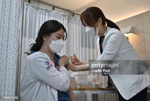 Medical worker receives the second dose of the Pfizer-BioNTech Covid-19 coronavirus vaccine at a vaccination centre on March 20, 2021 in Seoul, South...