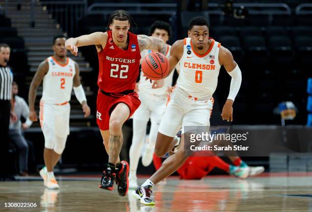 Clyde Trapp of the Clemson Tigers brings the ball up court late in the first half against Caleb McConnell of the Rutgers Scarlet Knights in the first...