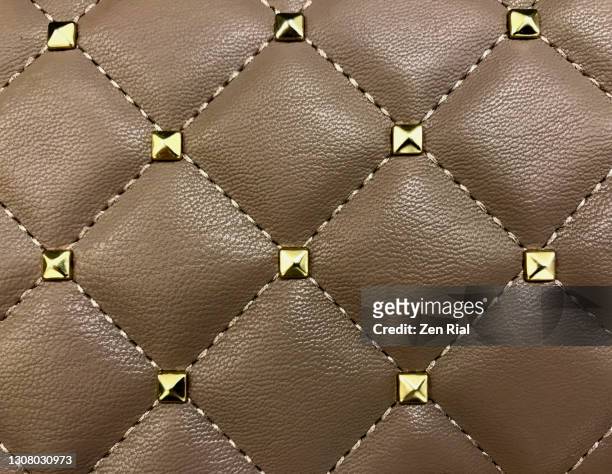 details of a brown handbag with metal studs and stitching - metallic purse ストックフォトと画像