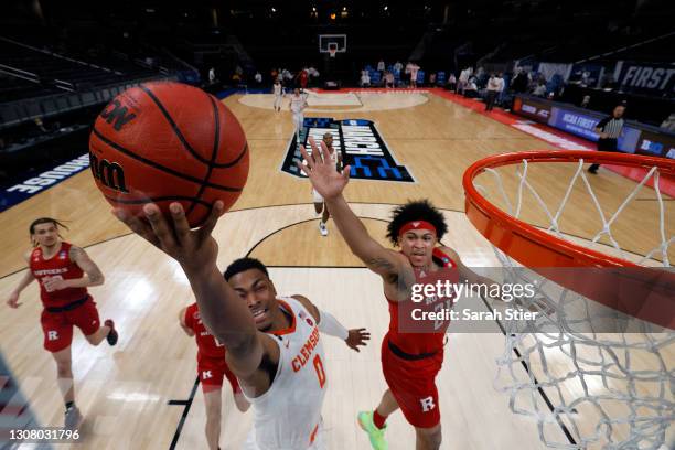 Clyde Trapp of the Clemson Tigers drives to the basket against Ron Harper Jr. #24 of the Rutgers Scarlet Knights in the first round game of the 2021...