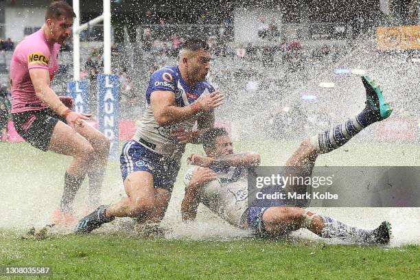 Nick Cotric and Corey Allan of the Bulldogs dive for the ball in the wet during the round two NRL match between the Canterbury Bulldogs and the...