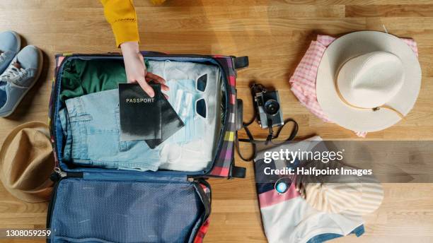 top view of young woman packing for summer holidays, coronavirus concept. - summer travel bag stock-fotos und bilder