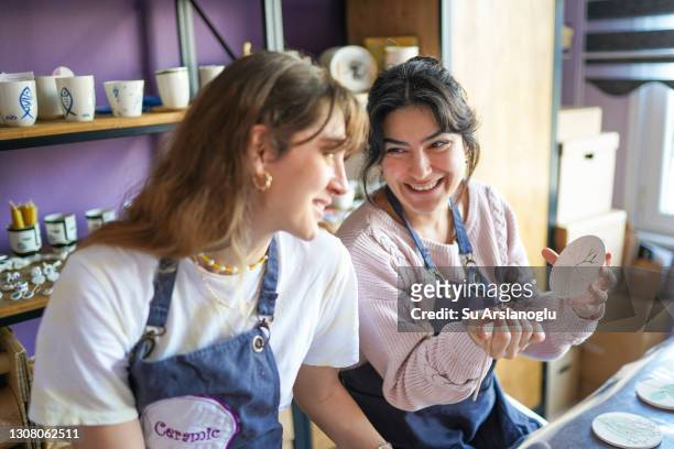 two women making ceramics at ceramic workshop - painting pottery stock pictures, royalty-free photos & images