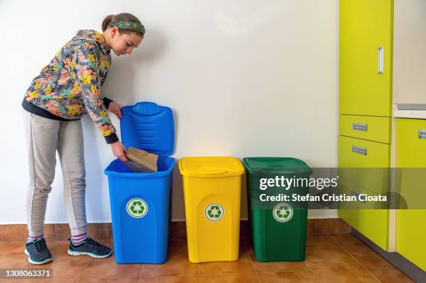 girl recycling paper at home - recycling bins stock pictures, royalty-free photos & images