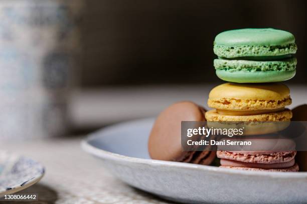 a stack of macaroons served on plate in kitchen - macaron stockfoto's en -beelden