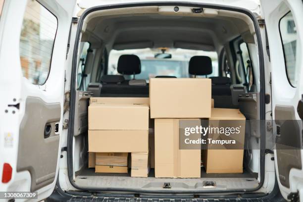 rearview of a delivery van with cardboard packages - delivery truck stock pictures, royalty-free photos & images