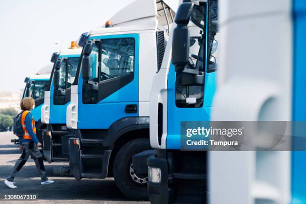 ein müllsammler, der auf einen müllwagen zuläuft. - garbage truck stock-fotos und bilder