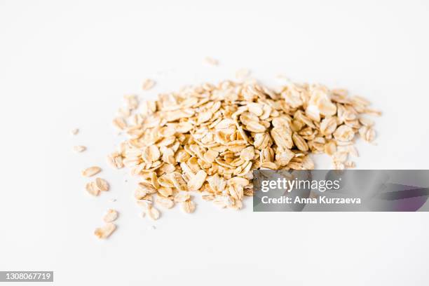 oat flakes isolated on white background - oat stockfoto's en -beelden