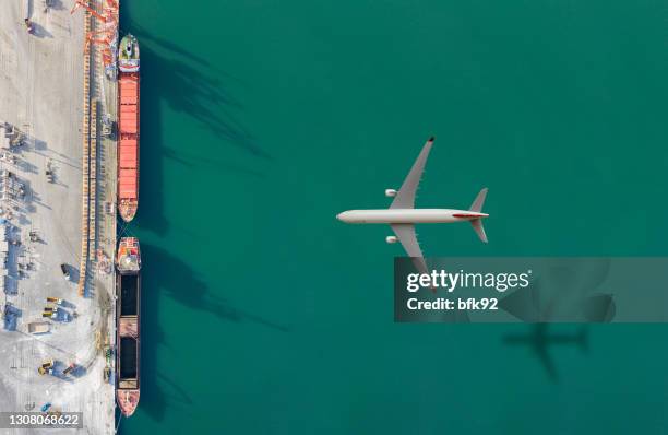aereo che vola sopra la nave da carico. - aereo cargo foto e immagini stock