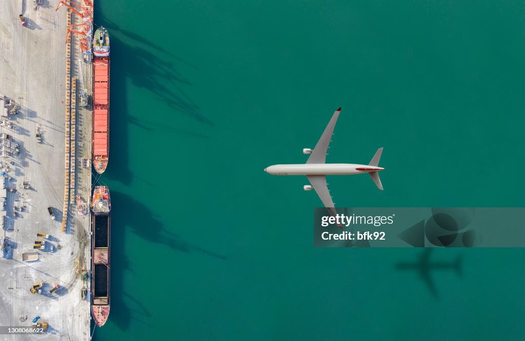 Airplane flying above the cargo ship.