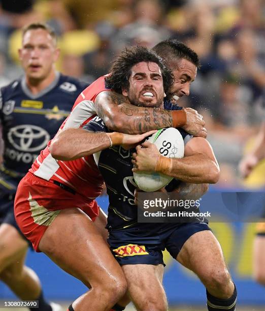 Jake Granville of the Cowboys is tackled by Paul Vaughan of the Dragons during the round two NRL match between the North Queensland Cowboys and the...