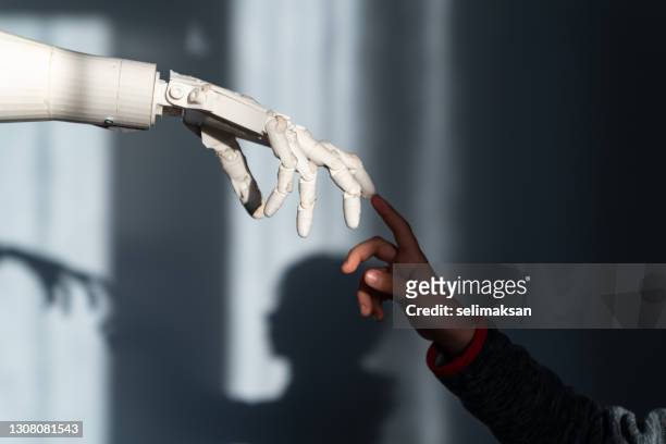boy touching robot's finger - robot hand human hand stock pictures, royalty-free photos & images