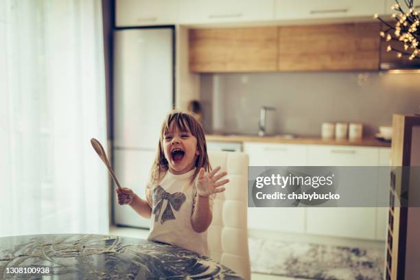 little girl singing an yelling while making mess in kitchen - messy kitchen stock pictures, royalty-free photos & images