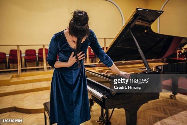female pianist bowing after performance - bowing stock pictures, royalty-free photos & images