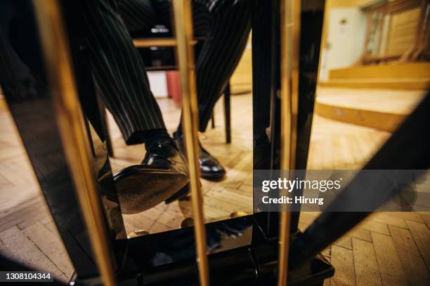 male pianist pressing piano pedal - soloist stock pictures, royalty-free photos & images