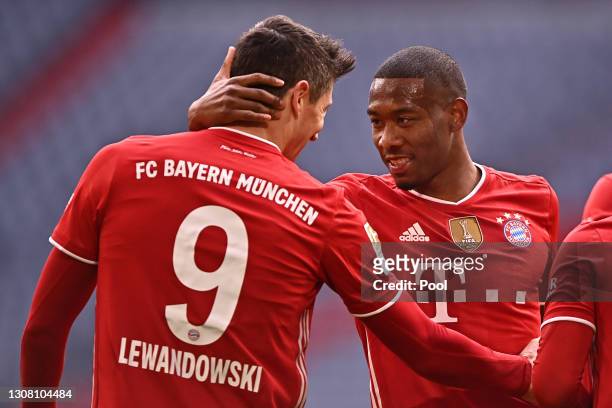 Robert Lewandowski of FC Bayern Muenchen celebrates with David Alaba after scoring their side's third goal during the Bundesliga match between FC...