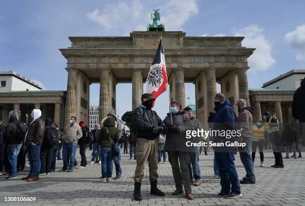 Neo-Nazis, one of whom is holding a German Empire flag, gather at the Brandenburg Gate on March 20, 2021 in Berlin, Germany. Several right-wing...