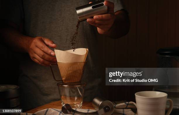 cropped view a man making coffee in the dark mood - coffee grinder 個照片及圖片檔