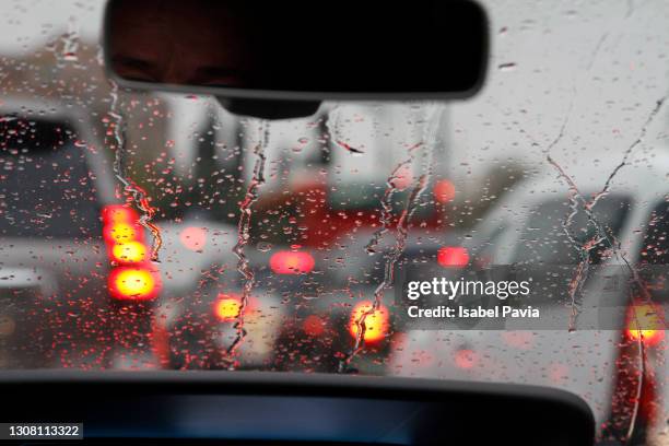 view from car with rain drops of traffic jam in the street - file stockfoto's en -beelden